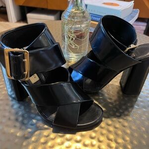 Block heel sandal with gold buckle and ankle strap.